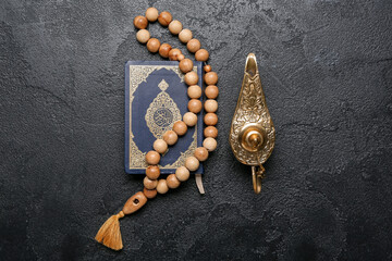 Aladdin lamp of wishes, Koran and prayer beads for Ramadan on dark background