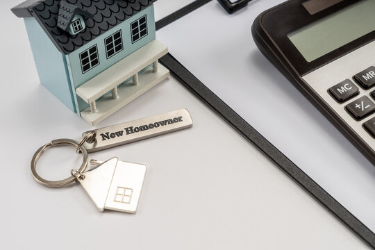 House model, house key and calculator on white background, home loan and investment concept.