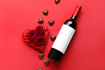 Bottle of wine, chocolate candies and rose flowers on red background. Valentine's Day celebration