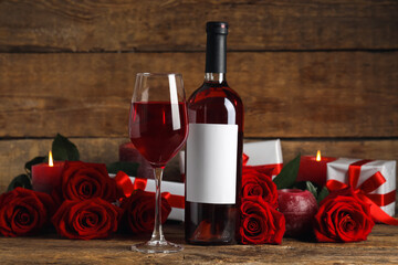Glass of wine, bottle, rose flowers and gifts on wooden background. Valentine's Day celebration