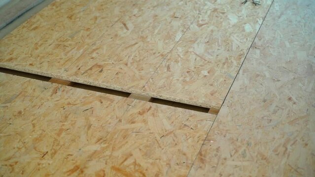 Close-up of an installed subfloor made of oriented strand board. Surface leveling OSB panels. Smooth camera movement