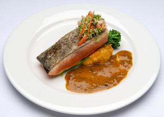 Grilled or Broiled Salmon with Broccolini, Asparagus and Sweet Potato Mash and a seafood sauce.