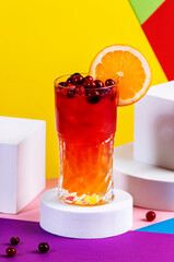Tequila Madras alcoholic cocktail with silver tequila, orange and cranberry juice and ice. Modern style still life on  trendy bright multicolored background