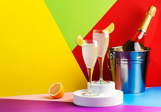 French 75, alcoholic cocktail with dry gin, prosecco, syrup and lemon juice. Modern style still life on bright multi-colored background
