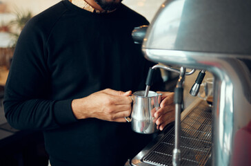 Hands, man and barista brewing coffee at cafe using machine for hot beverage, caffeine or steam. Hand of employee male steaming milk in metal jug for premium grade drink or self service at shop