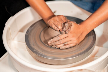 earthenware The art of sculpting clay with ceramics being molded by hand on a spinning machine. with the right posture to create a plate or vase professionally
