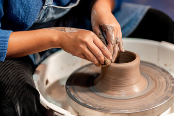 earthenware The art of sculpting clay with ceramics being molded by hand on a spinning machine. with the right posture to create a plate or vase professionally