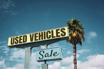 Fototapeta premium Aged and worn vintage used cars sign with palm tree