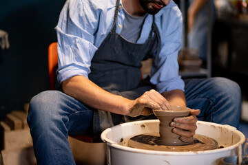 earthenware The art of sculpting clay with ceramics being molded by hand on a spinning machine. with the right posture to create a plate or vase professionally