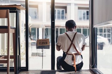 Young male manager in restaurant. Man coffee shop owner with close sign. Small business concept