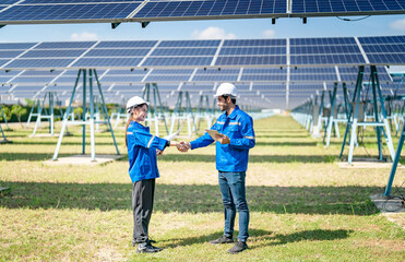 Engineer and Female Apprentice Working Together On Solar Farm Installation.