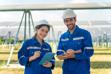 Engineer and Female Apprentice Working Together On Solar Farm Installation.
