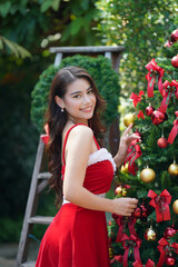 Beautiful female Santa, Portrait of beautiful happy young woman with red Santa skirt against Christmas tree
