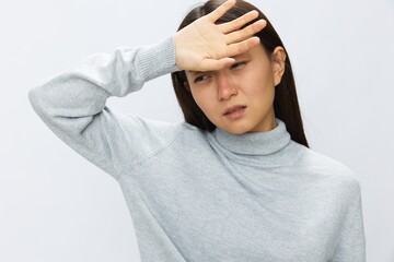 Asian woman holding her hand to her head for severe headache, migraine white background