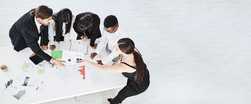 Meeting, Finance And Collaboration With A Business Team Working Around A Table In The Boardroom From Above. Accounting, Documents And Teamwork With A Man And Woman Employee Group At Work In An Office