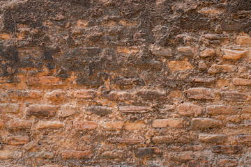Aged brick wall surface with damaged plaster