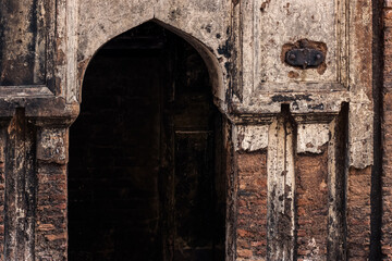 Fototapeta na wymiar Entry door of an old damaged haunted building