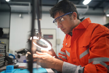 Worker inspecting engineering parts that have been cleaned and  examining machine part 