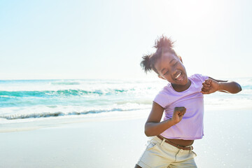 Children, beach and dance with a black girl having fun alone on the sand in summer by the sea or ocean. Nature, kids and blue sky with a female child dancing by the water while on holiday or vacation