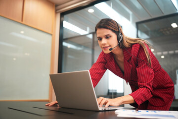 Cheerful attractive young businesswoman having online business meeting on laptop