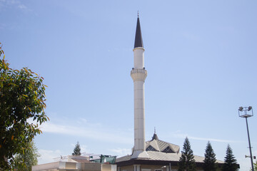 Minaret of mosque against blue sky.