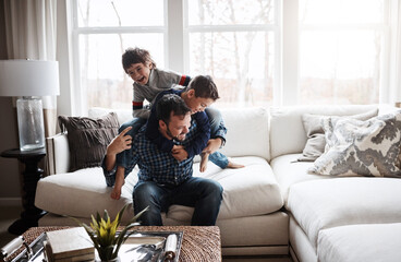 Playful, bonding and father with children on the sofa for playing, quality time and crazy fun. Love, happy and boy kids piling onto their dad with energy on the couch of their family home together - Powered by Adobe