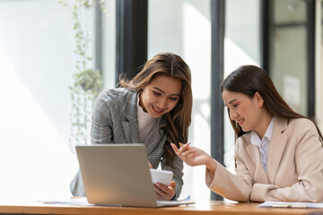 Young colleagues discuss business and analytical price charts using calculators and laptops to calculate financial, tax, accounting, statistics and analytical research