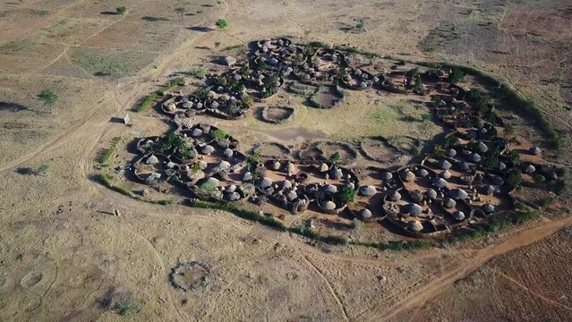 Aerial view of drone approaching a village in the Karamoja region, also called Manyatta or Ere, in Uganda, during a sunny day.