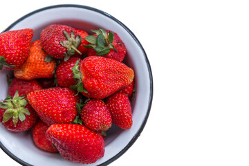 Juicy fresh large strawberries with green tails in a bowl. Vitamins and health from nature. Top view. Isolated on white background. Space for text.