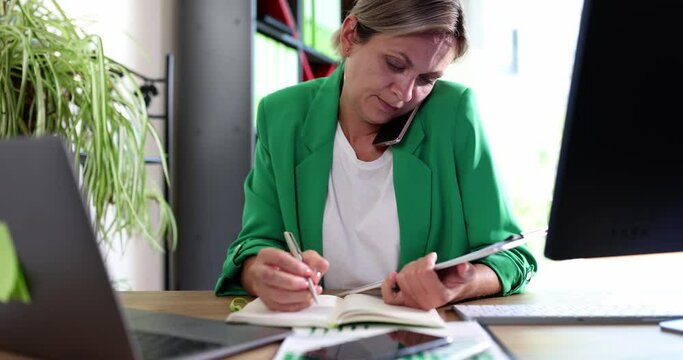 Tired businesswoman talking on phone and typing on computer at same time 4k movie slow motion 