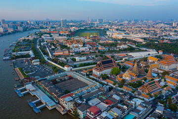 Fototapeta na wymiar Aerial view Day to Night of Chao Phraya River with Royal Grand Palace and Emerald Buddha Temple Landmark of Bangkok, Thailand. Amazing Drone Footage over the City skyline in twilight.