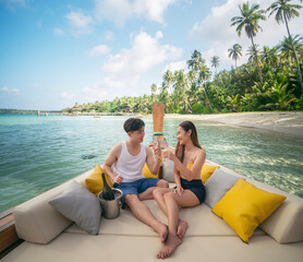 Asian couple lover travel and relax in they honeymoon trip on the wooded boat at Koh kood island