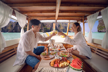 Asian couple lover travel and relax in they honeymoon trip on the wooded boat