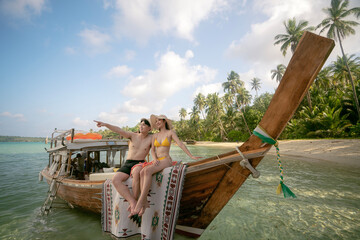 Asian couple lover travel and relax in they honeymoon trip on the wooded boat - obrazy, fototapety, plakaty