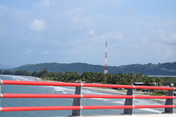 Fototapeta na wymiar the end of the crossing bridge between cities, with views of the red-fenced beach, Youtefa Jayapura Bridge, Papua