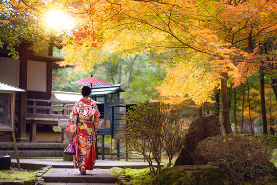 Asian traveler girl in Kimono traditional dress walking in old temple in Autumn season