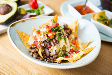 Nachos with guacamole. Nachos are a dish of Mexican origin, which consists of frying pieces of corn tortilla covered with a special cheese.