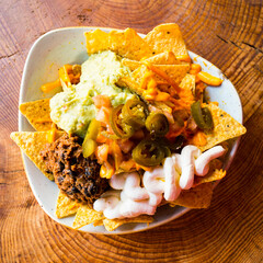 Nachos with guacamole. Nachos are a dish of Mexican origin, which consists of frying pieces of corn tortilla covered with a special cheese.