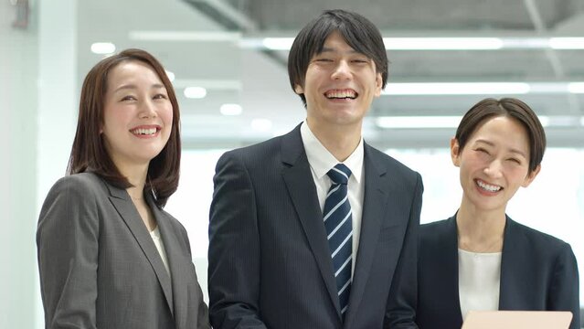 笑顔でカメラ目線のスーツを着た日本人男女