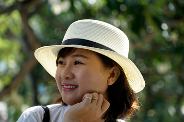 Happy Asian Female student wearing yellow headphone at the park 