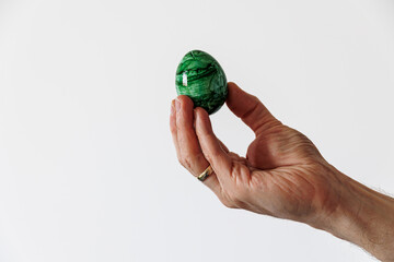 colored easter eggs in a male hand on a light background