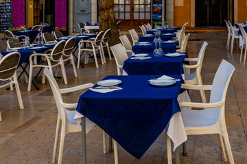  white tables with navy blue tablecloth in restaurant waiting for customers in spain