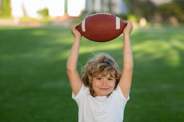 Obraz premium Football game, rugby, american football. Child boy playing football outdoor.