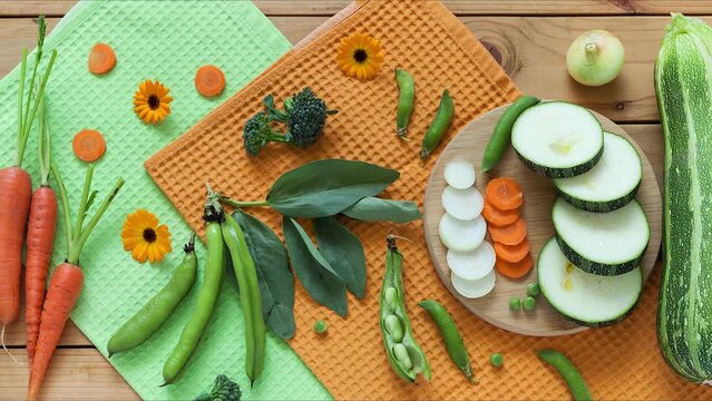 Prepare a healthy light vegetable stew with fresh seasonal vegetables: carrots, onions, zucchini, beans, peas and broccoli. Freshly harvested vegetables on a wooden table. Organic foof concept