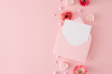 Valentines Day concept. Flat lay photo of pink envelope with letter, heart shaped candles and...