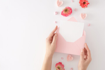 Women day concept. Flat lay photo of pink envelope with letter in hands, heart shaped candles and...