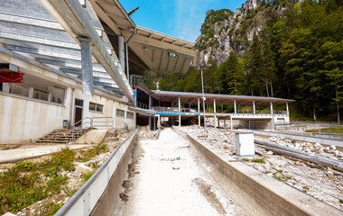 Bayern Eisarena Bobsledding track, Eisstadion out of order at Schönau am Königssee. Berchtesgadener Land, Alps, Germany. 2022: out of service. scree and debris. Destruction by Rain and storm.