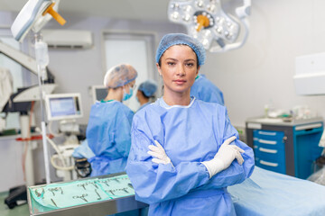 Portrait of smiling surgeon in hospital. Female healthcare worker is wearing scrubs. She is...