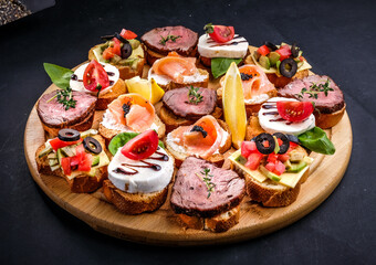 bruschetta with meat, cheese, salmon, lemon, tomato, olive