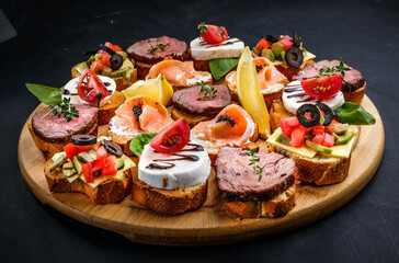 bruschetta with meat, cheese, salmon, lemon, tomato, olive